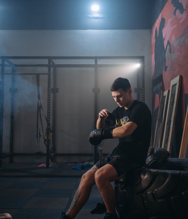 Man performing a controlled strength exercise in a dark gym with magenta light.